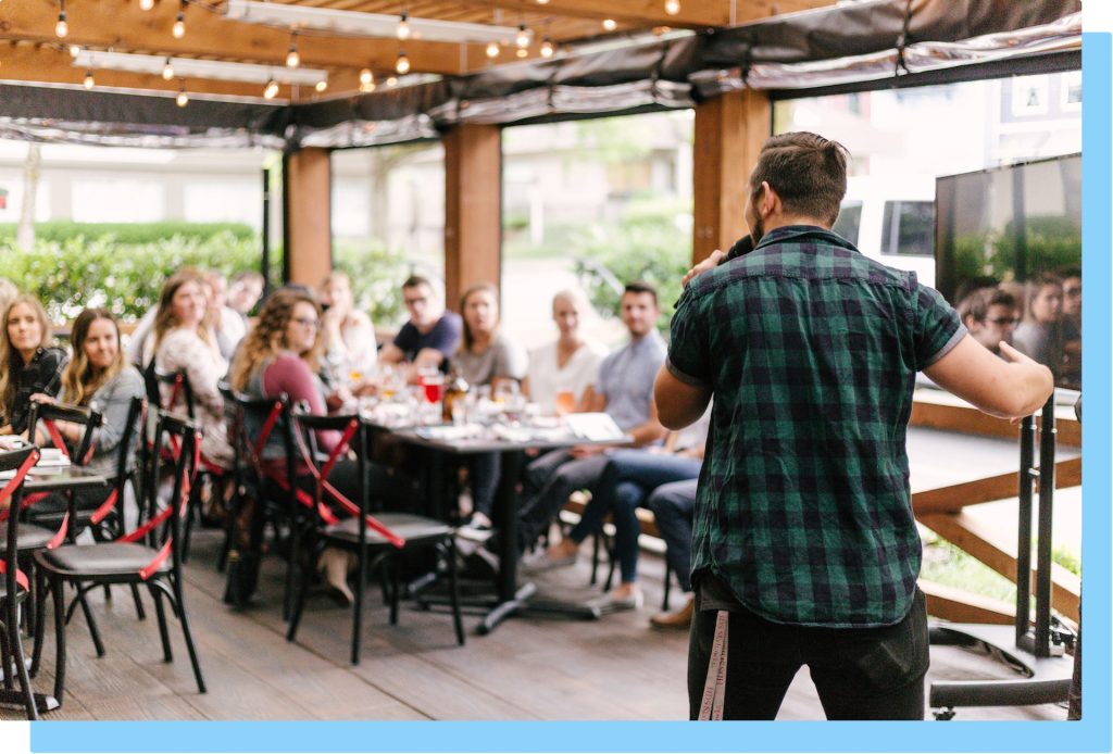 Man speaking in front of networking event.