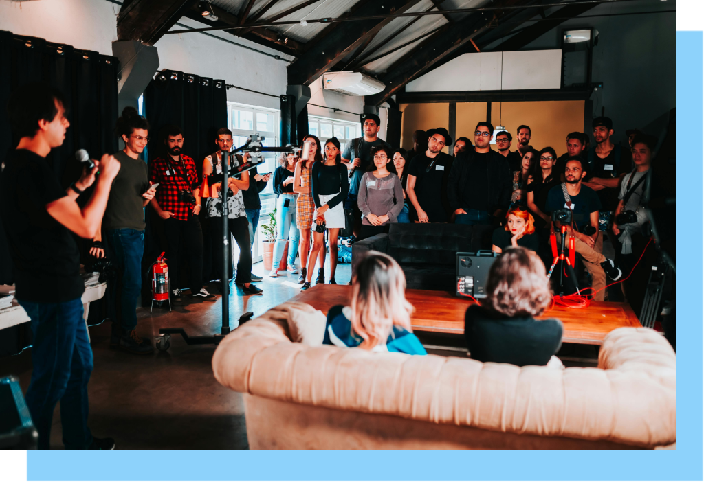 Group of people listening to someone else talk at a large networking event.