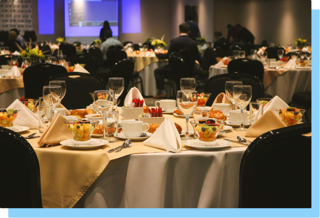 table at a networking event with glasses, cutlery, and plates all set